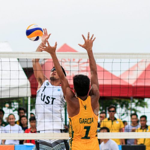 Beach volleyball action shot of two players competing at a tournament in Pasay, Philippines.